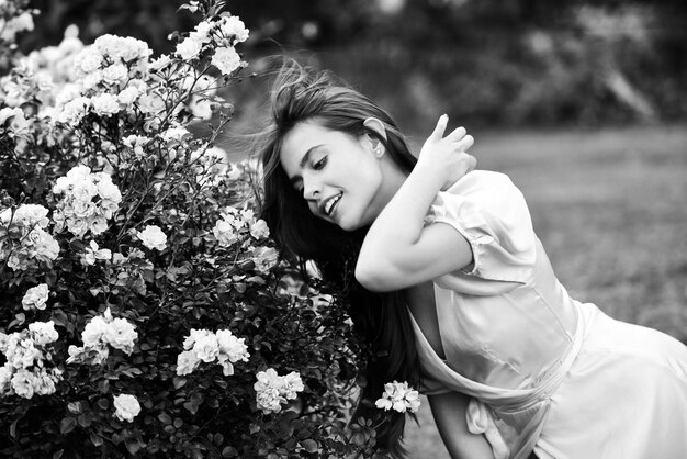 Mulher primavera no jardim de rosas ao ar livre Beleza natural aproveite a recreação de verão