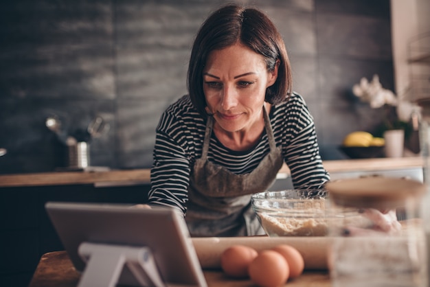 Mulher procurando receita de torta de maçã sobre o tablet