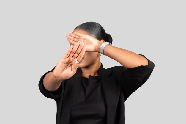 Mulher profissional afro-americana em um terno de negócios fazendo um gesto de timeout com as mãos