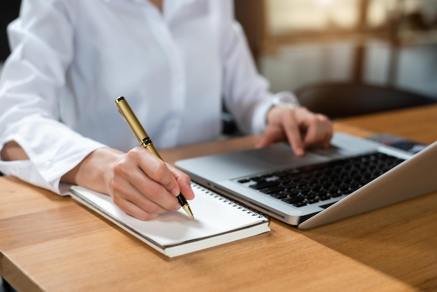 Mulher profissional escrevendo seus conceitos de ideia no notebook enquanto trabalhava em seu projetoxA