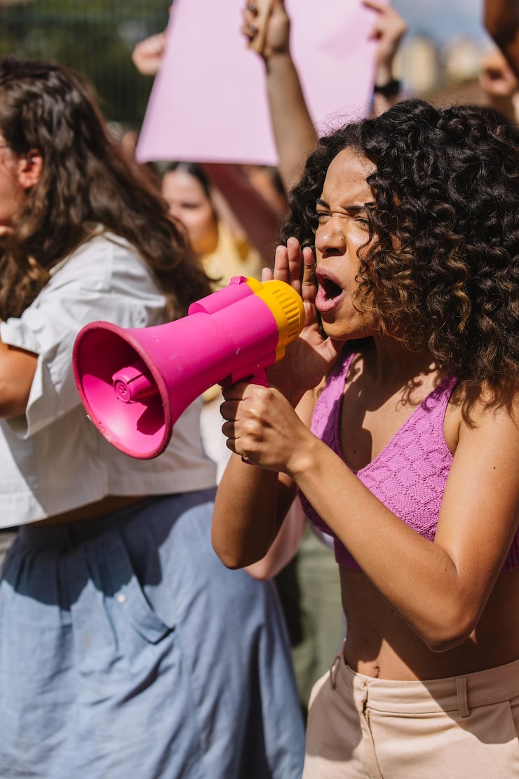 Foto mulher protestando com um megafone no meio da multidão foto vertical