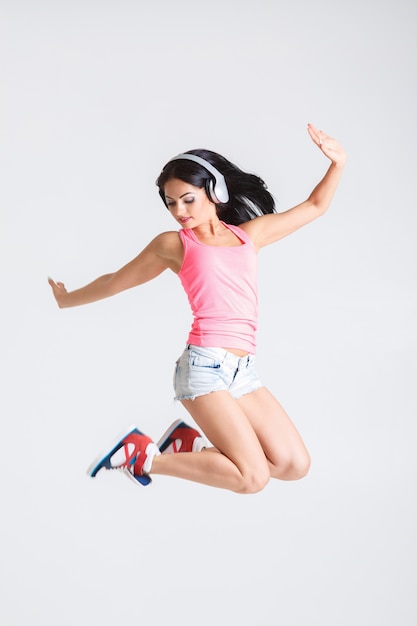 Mulher pulando em fones de ouvido para música