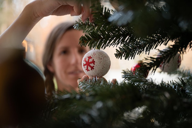 Foto mulher que decora a árvore de natal