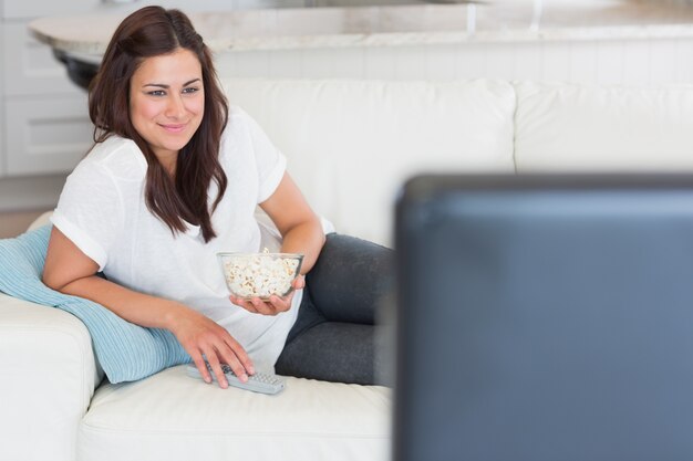 Foto mulher que gosta de tv com pipoca