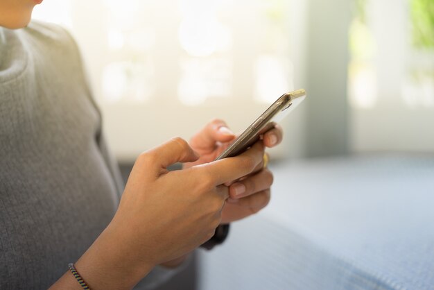 Mulher que olha o telefone esperto usando-se como o conceito do negócio.