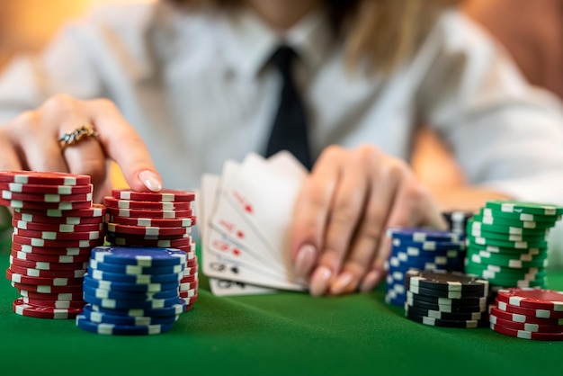 mulher que sabe como jogar poker perfeitamente senta-se em uma mesa de poker com cartas e fichas dinheiro conceito de jogo isolado em plano de fundo