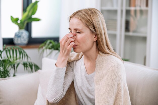 mulher que toca o nariz e sofre de alergia sazonal