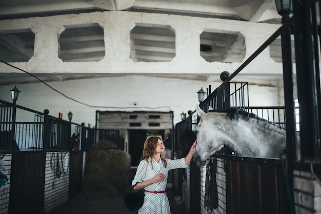 Mulher que toca o rosto de um cavalo