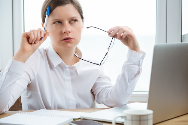 Mulher que trabalha com computador fica com expressões de pensamento tristes. Problema no trabalho