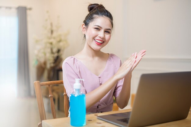 Mulher que trabalha em casa com gel de álcool