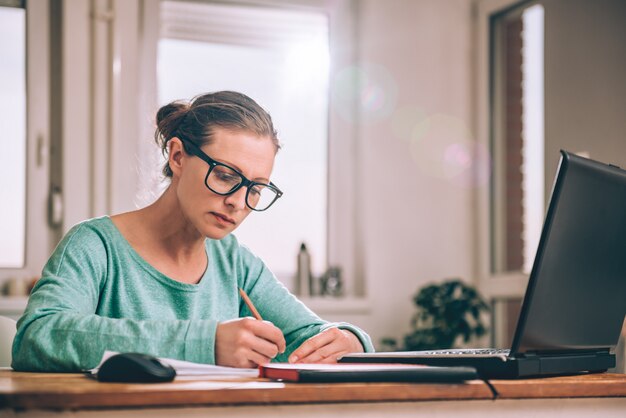 Mulher que trabalha em casa, escritório