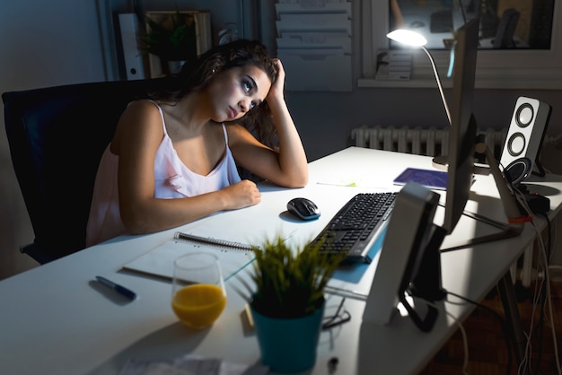 Mulher que trabalha em um computador em casa.