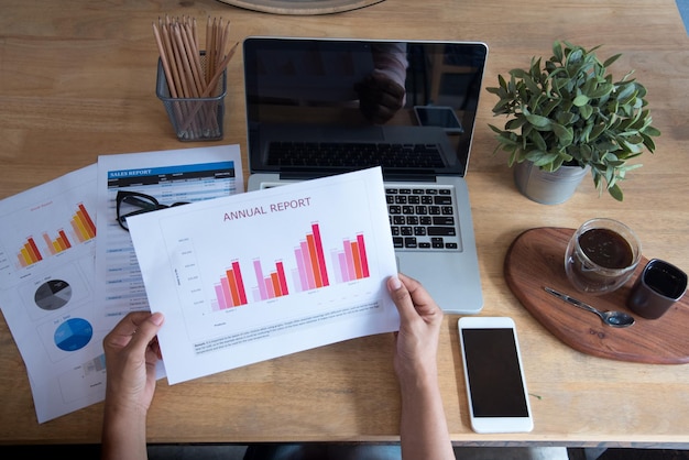 Mulher que trabalha na mesa de escritório de negócios usando o laptop trabalha em casa Mulher de negócios procurando infográfico gráfico de gráfico de negócios financeiros analisar estatísticas de venda Mãos de mulher na mesa de escritório do empresário