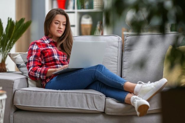 Mulher que trabalha no laptop em casa