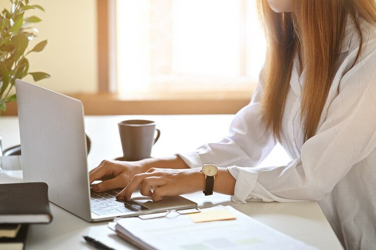 Foto mulher que usa o laptop na tabela com a foto colhida do tiro.