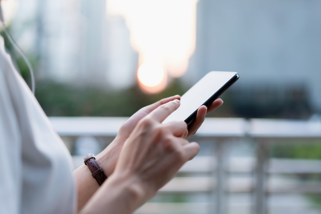 Mulher que usa o smartphone, durante o tempo de lazer. O conceito de usar o telefone é essencial na vida cotidiana.