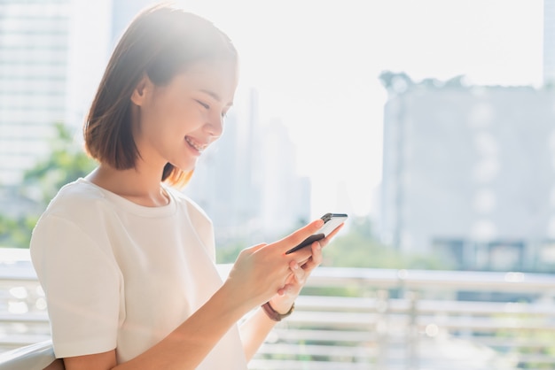 Mulher que usa o smartphone, durante o tempo de lazer. O conceito de usar o telefone é essencial na vida cotidiana.