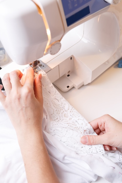 Mulher rabiscando tecido na máquina de costura na mesa