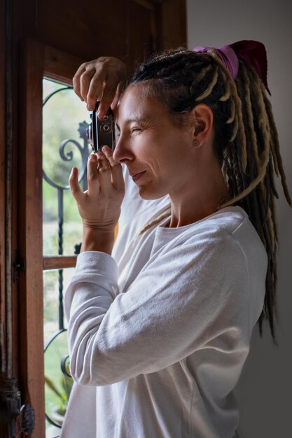 Mulher rasta com câmera retro tirando fotos