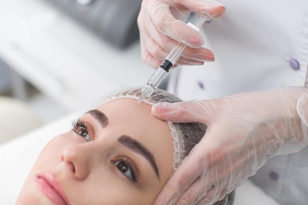 Mulher recebe injeção no rosto mulher bonita aplicando injeções de botox