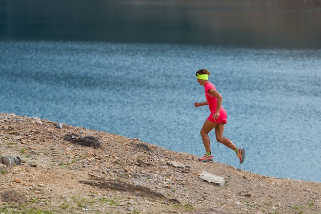 Foto mulher recebe treino trilha perto de um lago alpino