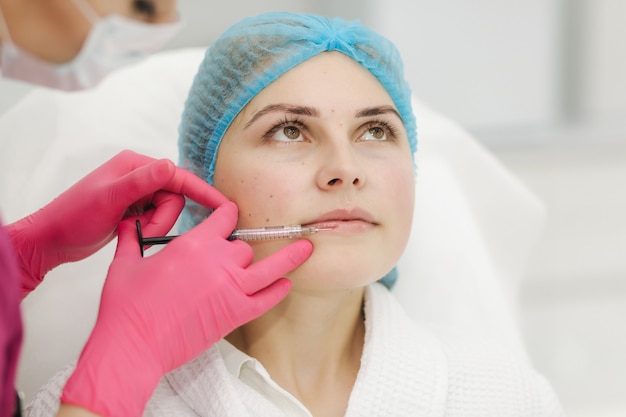 Mulher recebendo injeção de beleza para os lábios em salão de beleza