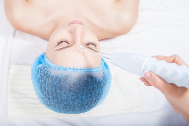 Mulher recebendo limpeza de pele de ultra-som no salão de beleza