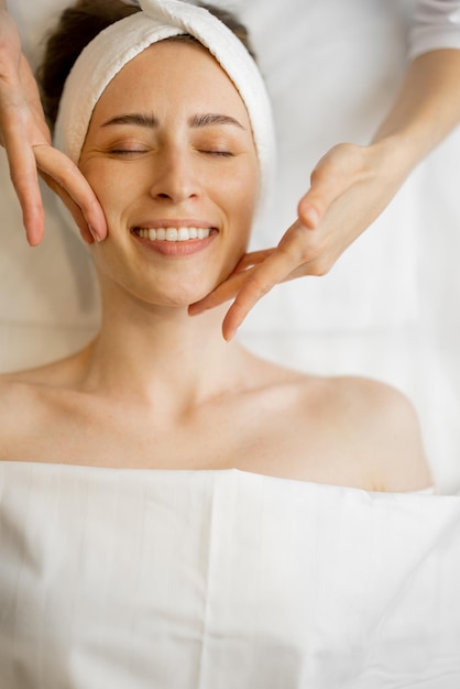 Mulher recebendo massagem facial relaxante