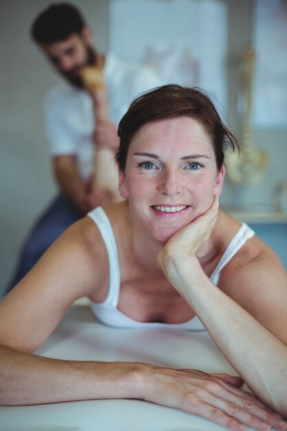 Mulher recebendo massagem nas pernas do fisioterapeuta