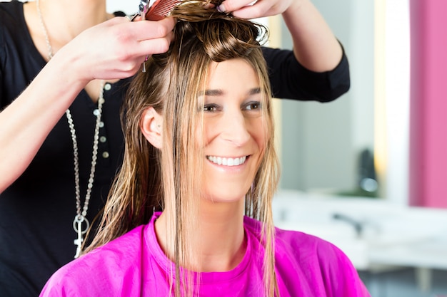 Mulher recebendo o corte de cabelo de cabeleireiro ou cabeleireiro