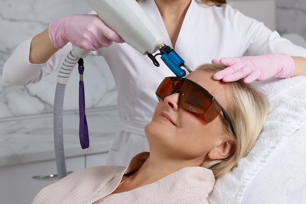 Mulher recebendo tratamento a laser na clínica de cosmetologia