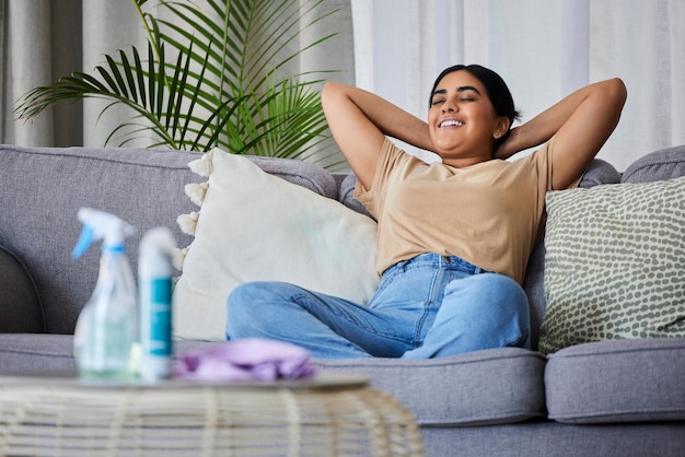 Garota feliz com telefone relaxa no sofá ou no sofá da sala