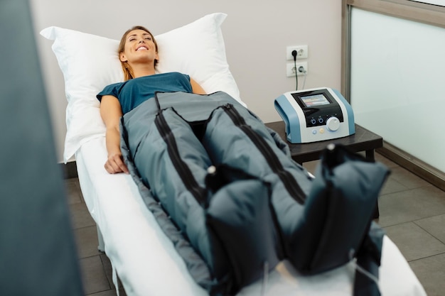 Mulher relaxada desfrutando de tratamento de pressoterapia no centro de bem-estar