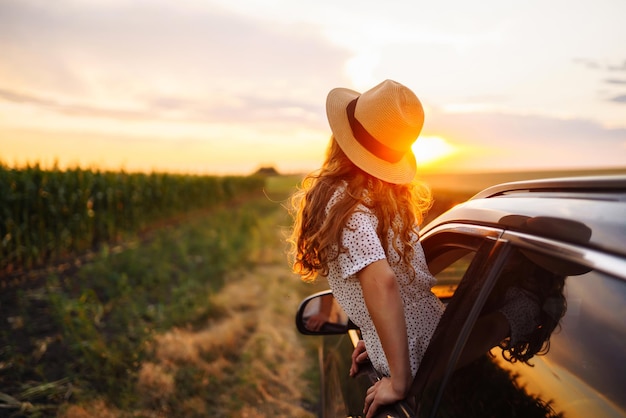 Mulher relaxada e feliz em uma viagem de verão, férias de viagem, inclinada para fora da janela do carro, estilo de vida.