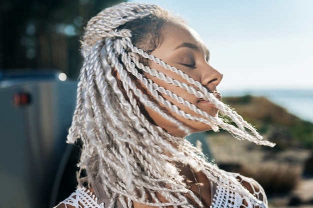 Mulher relaxada. mulher afro-americana bonita com dreads se sentindo relaxada enquanto descansa