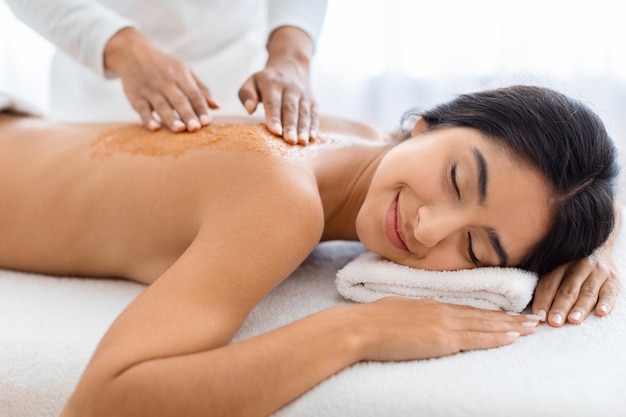 Mulher relaxada recebendo um tratamento de spa nas costas