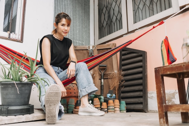 Mulher relaxando na rede do lado de fora de sua casa no conceito de staycation de verão