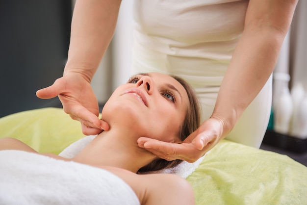 Mulher relaxante e desfrutando durante a massagem na cabeça