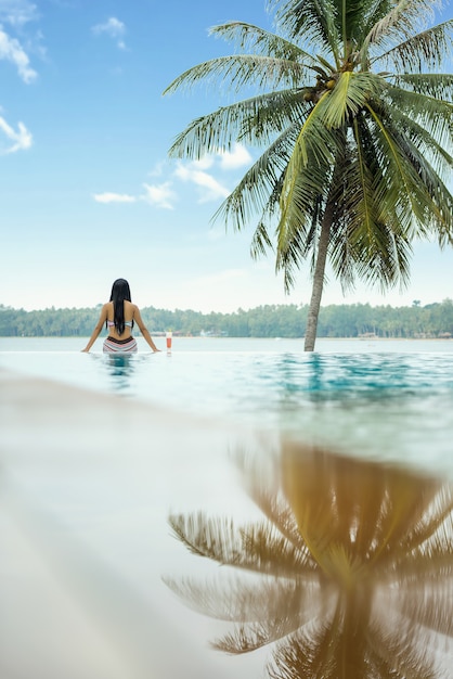 Mulher, relaxante, em, infinidade, piscina, olhar vista