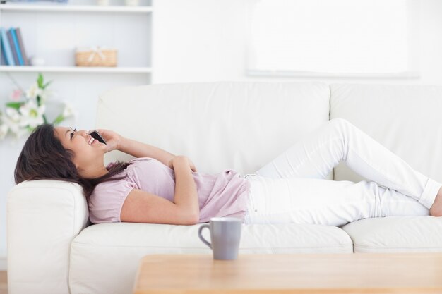 Mulher relaxante enquanto segura um telefone