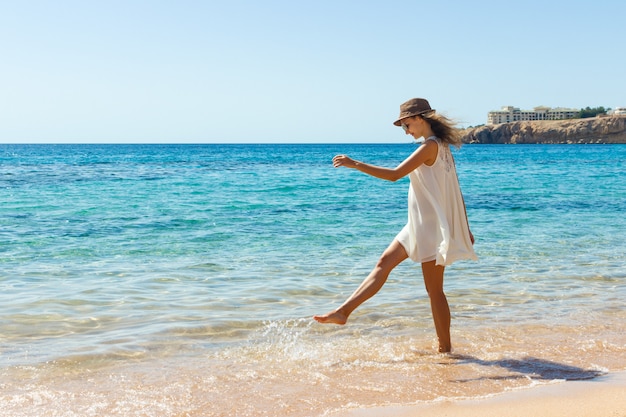 Mulher relaxante na praia, aproveitando a liberdade de verão. Garota feliz na praia