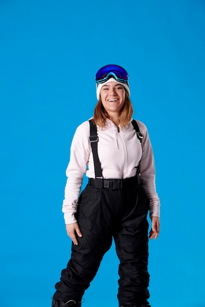 Mulher rindo em equipamento de neve e olhando para a câmera