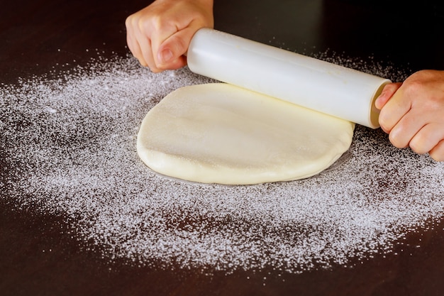 Mulher rolando fondant branco para decoração de bolos.