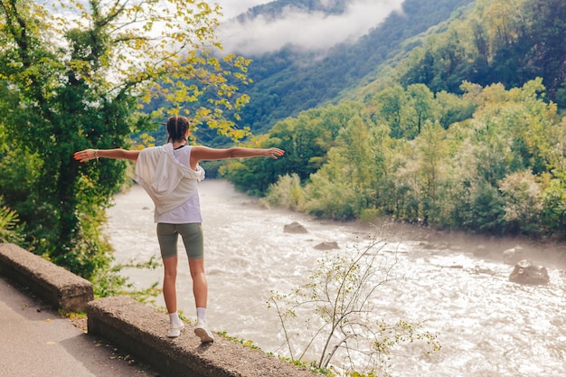 Foto mulher romântica feliz olhando para o rio na montanha na abkhazia