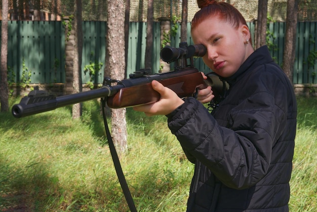 Foto mulher roxa jovem a proteger a casa ou em aulas de treinamento tático de armas. mulher com arma.