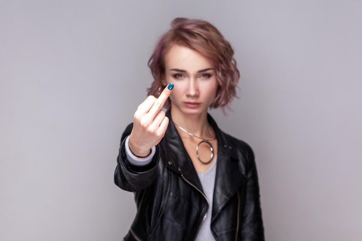 Foto mulher rude séria em pé mostrando o gesto indelicado do dedo médio olhando para a câmera