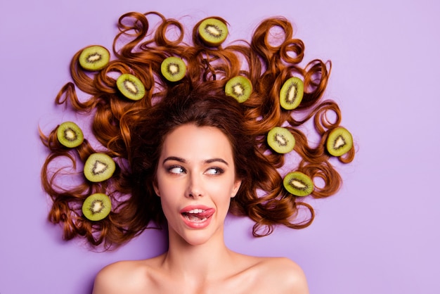 Mulher ruiva artística posando com kiwi no cabelo