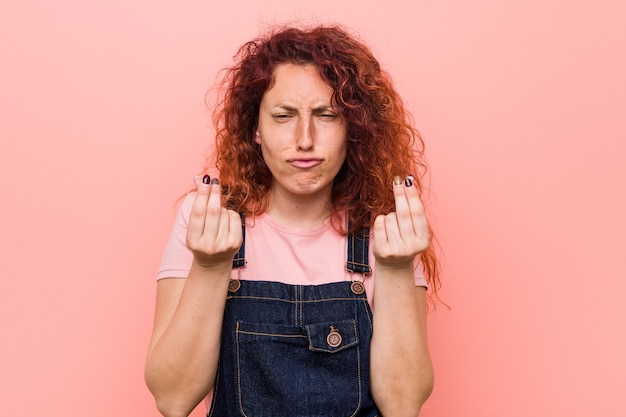 Mulher ruiva bonita jovem vestindo calça jeans, mostrando que ela não tem dinheiro.