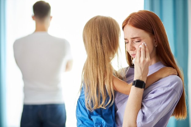 Mulher ruiva caucasiana com criança e menina deixando o homem enquanto ele se virava