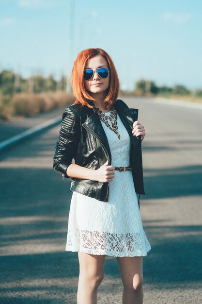 Mulher ruiva com uma jaqueta de couro preta na estrada